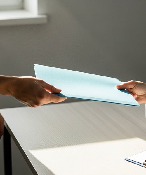 Пациент передает папку с документами врачу